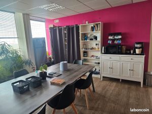 Espace pause avec grande table commune et machine à café