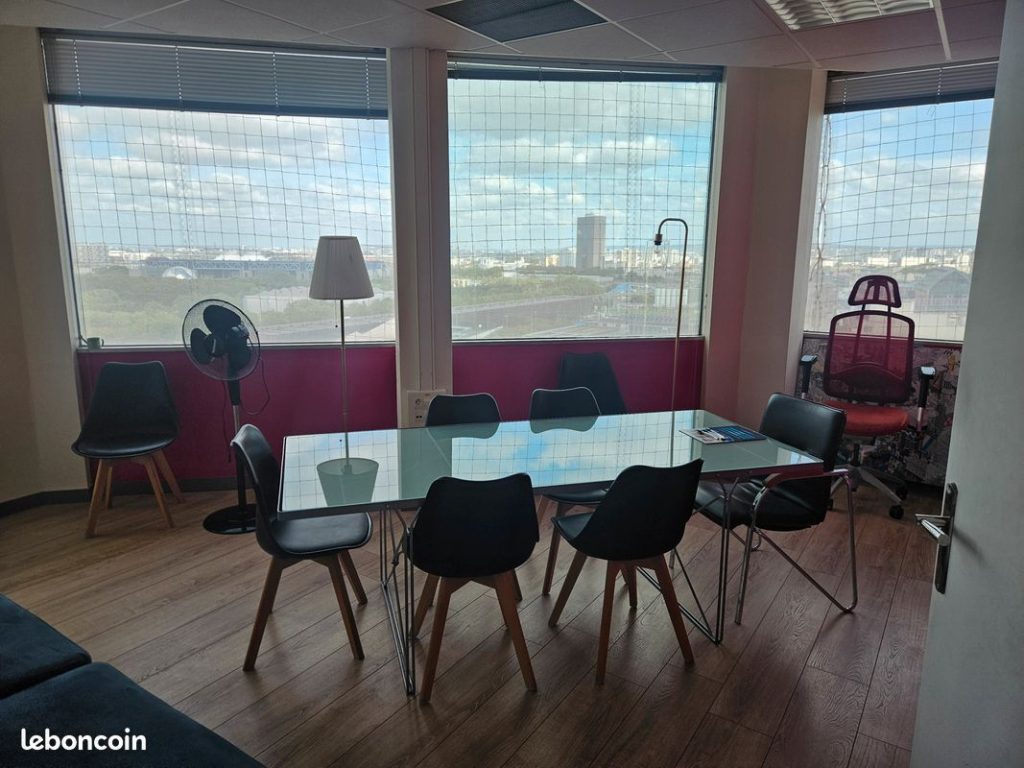 Table de réunion devant de grandes fenêtres avec vue sur Pantin