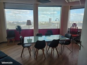 Table de réunion devant de grandes fenêtres avec vue sur Pantin