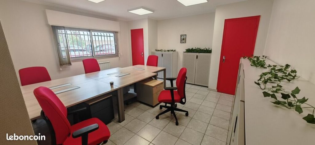 Bureau meublé avec table de travail et fauteuils rouges, quartier Cernay à Reims