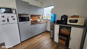 Cuisine partagée équipée avec machine à café et fontaine à eau, espace pause des bureaux de Roissy